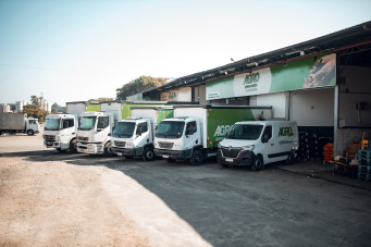 Fachada Agro Quarta Geração com caminhões estacionados